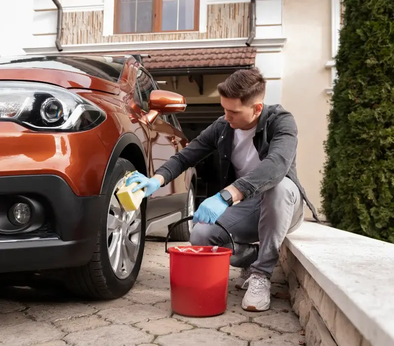 Lavage auto à domicile Ouilly-le-Tesson : professionnel intervenant sur un véhicule